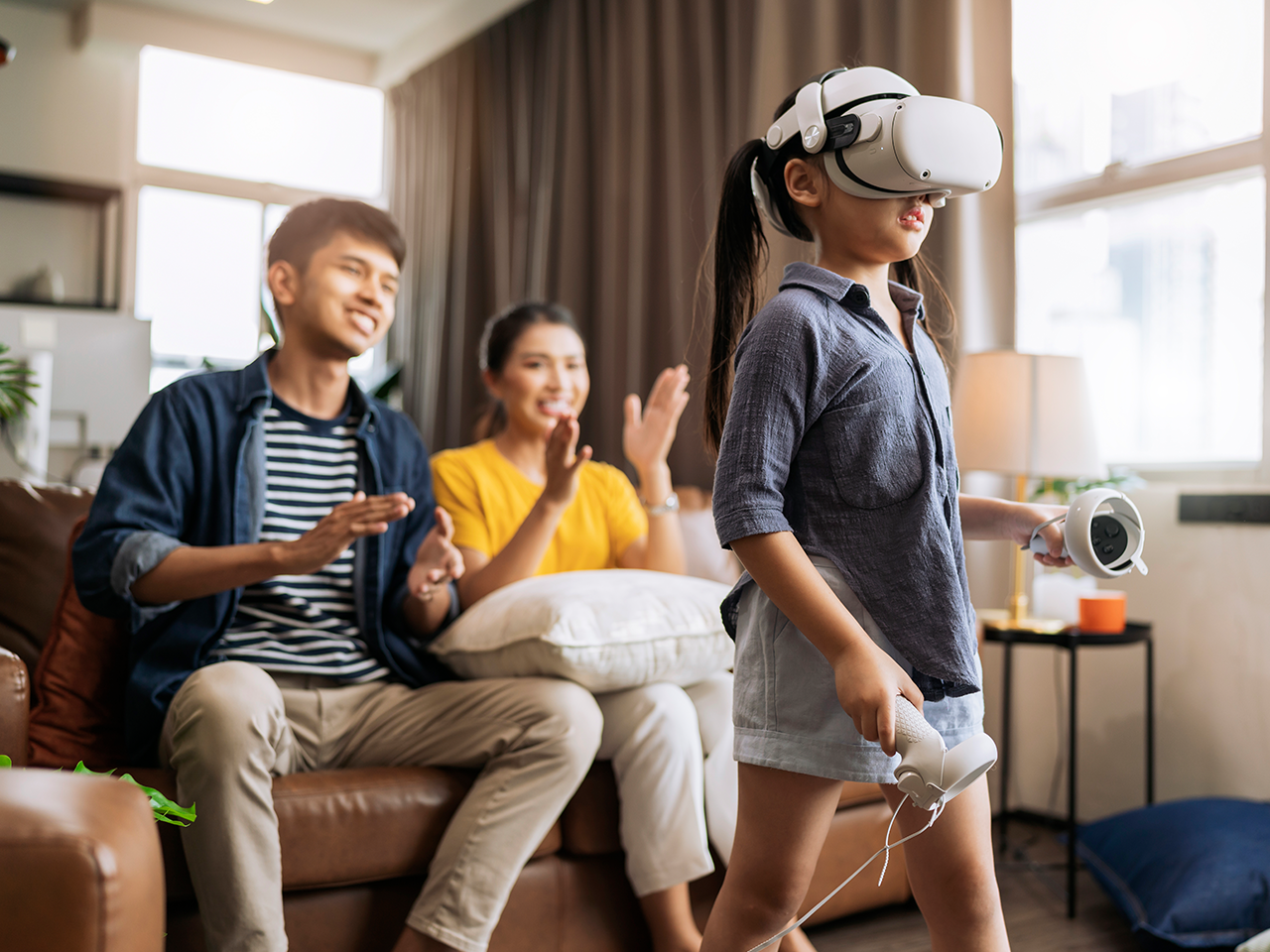 kid play VR while parent clap at background